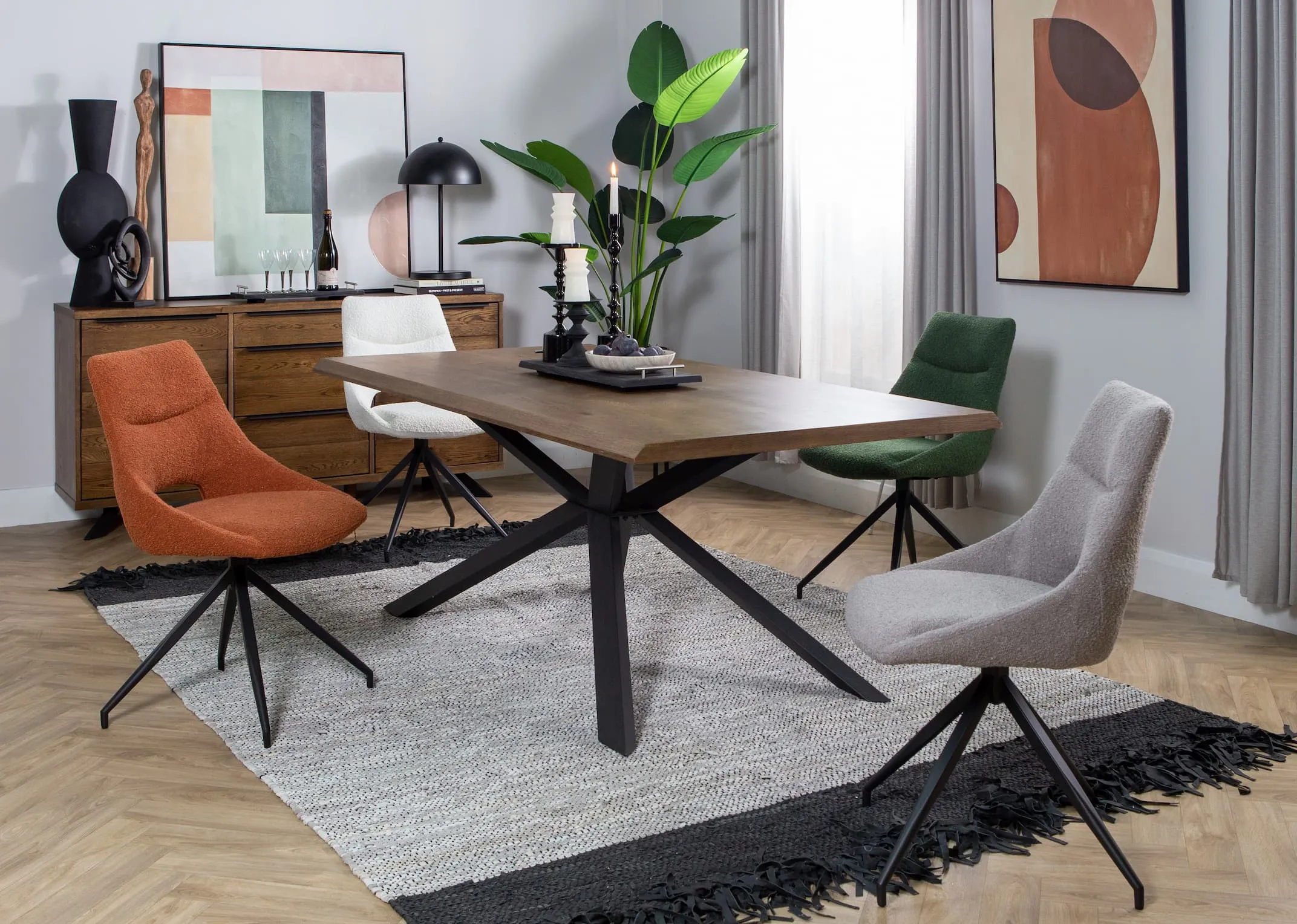 A lifestyle image of the Arno smoked oak dining table with Cobh chairs & arno sideboard with modern canvas collection