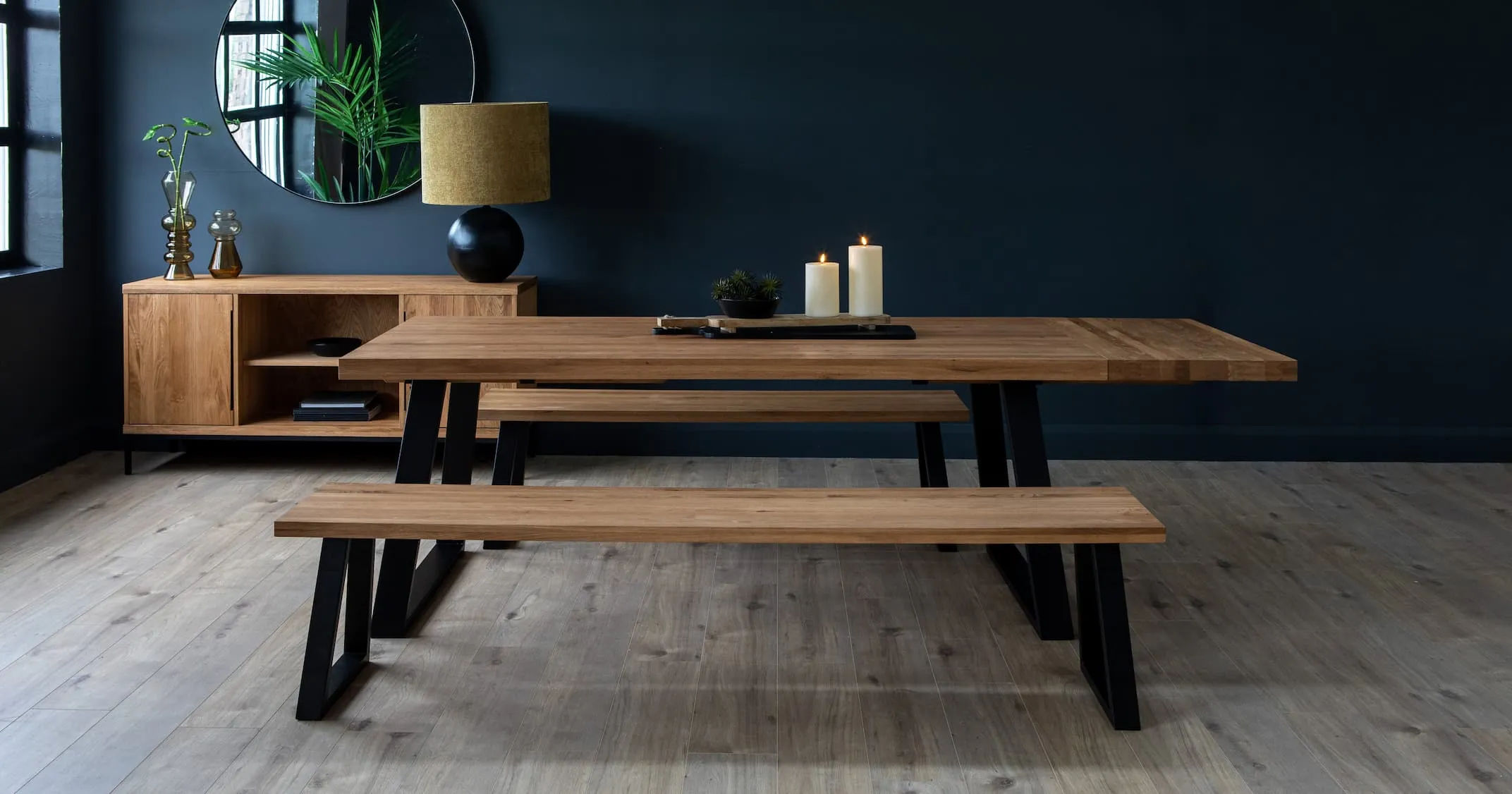 A lifestyle image of the Large Renvyle Dining table with bench & sideboard with bolcho lamp.