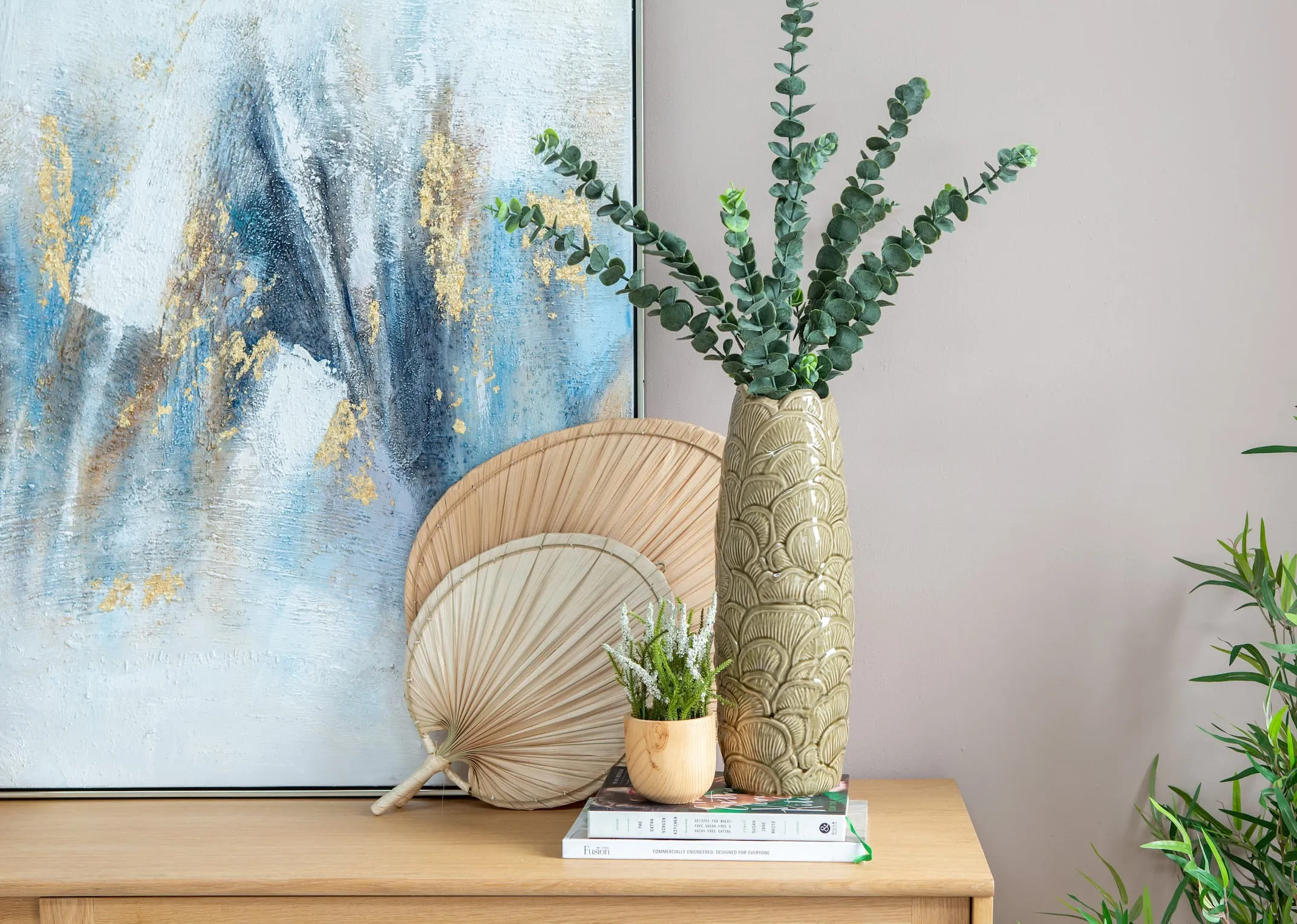 A lifestyle image of the Travis Vase with 3 -4 sprays of eucalyptus and coco fans.