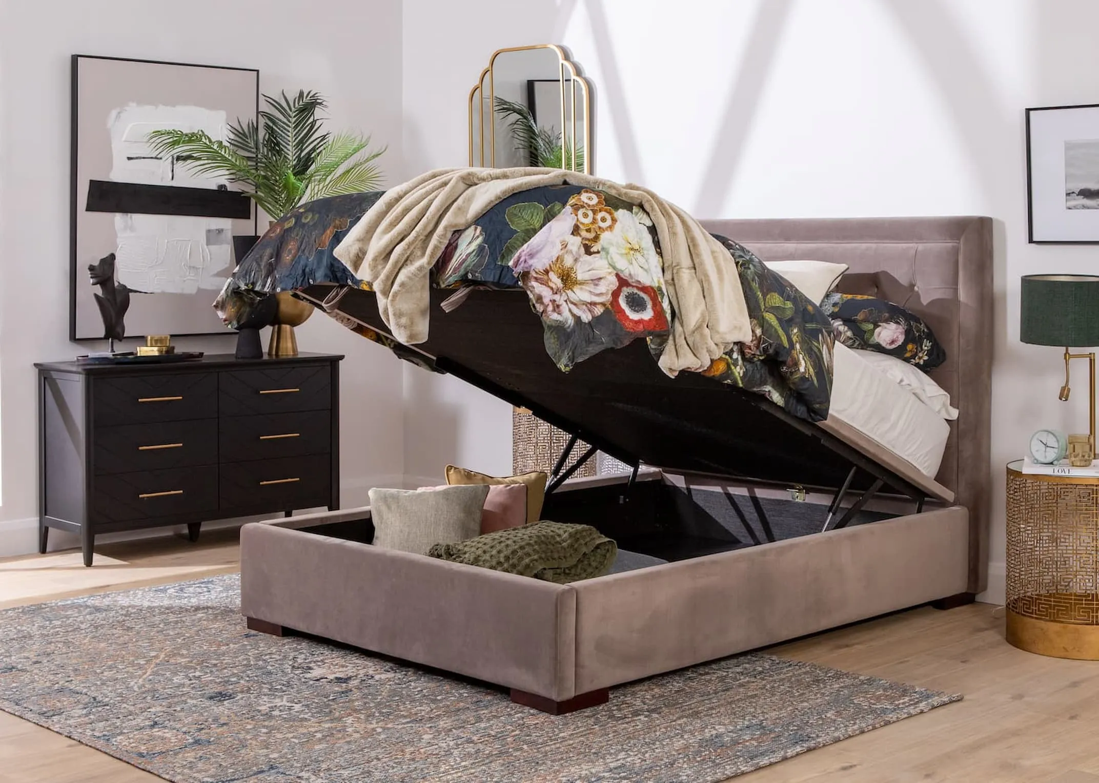 A taupe velvet ottoman bed with tufted high headboard from EZ Livings Majestic range. Side view of bed with ottoman open revealing underbed storage