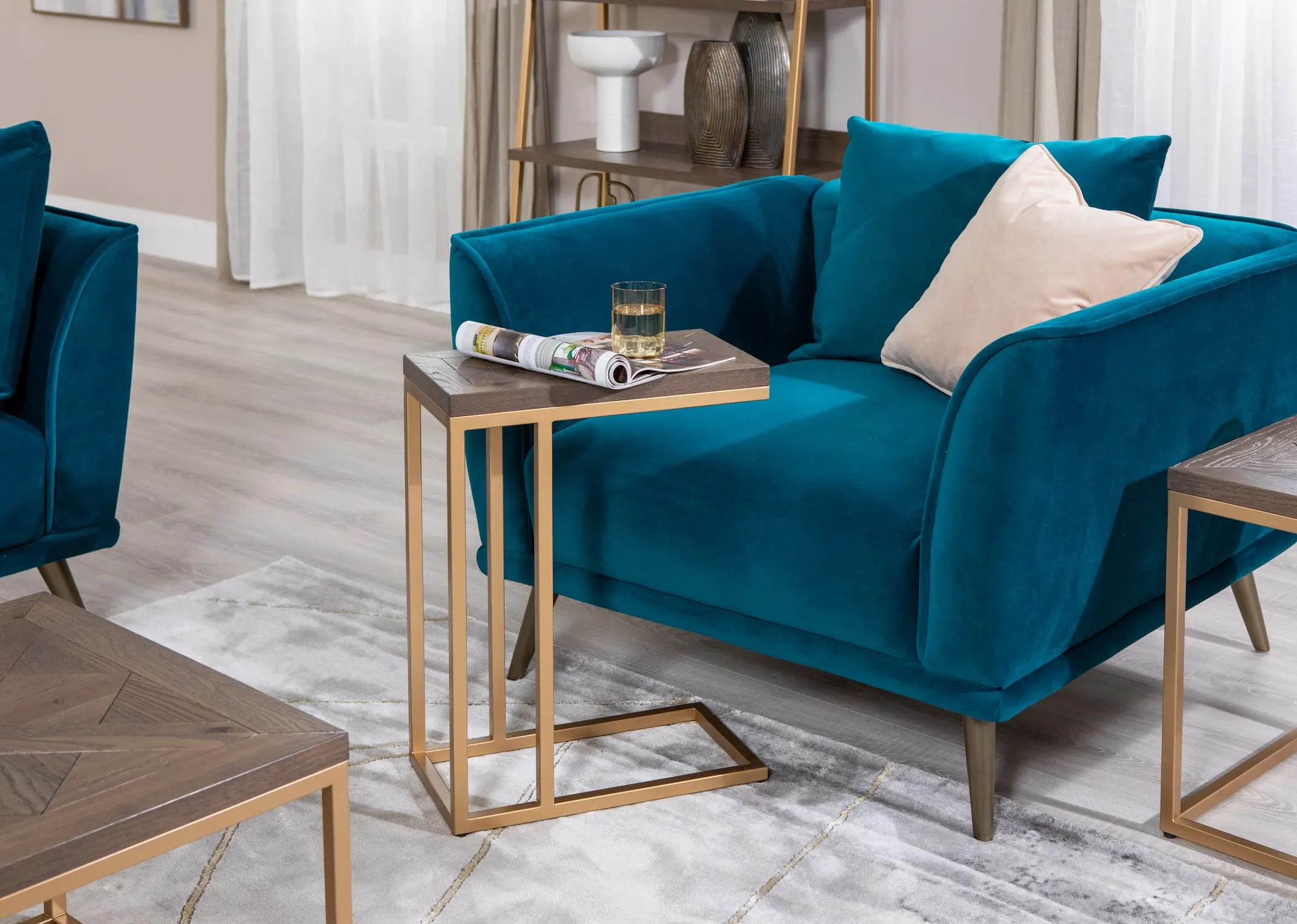 A lifestyle image of the Katie teal velvet cuddler with Greenwich sofa and lamp table