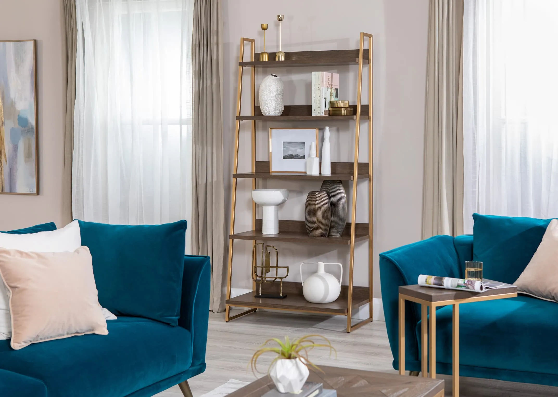 A lifestyle image of the Greenwich bookcase with sofas table teamed with Katie teal velvet sofas.