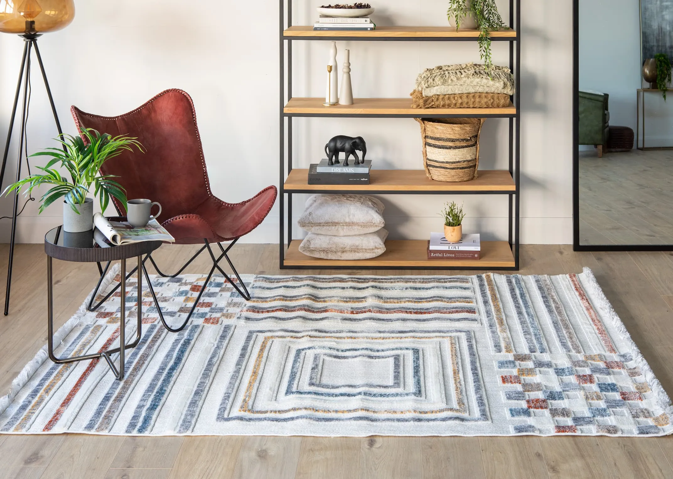 A lifestyle image of the Diego rug with Ranger red chair and Mila bookcase with an assortment of baskets