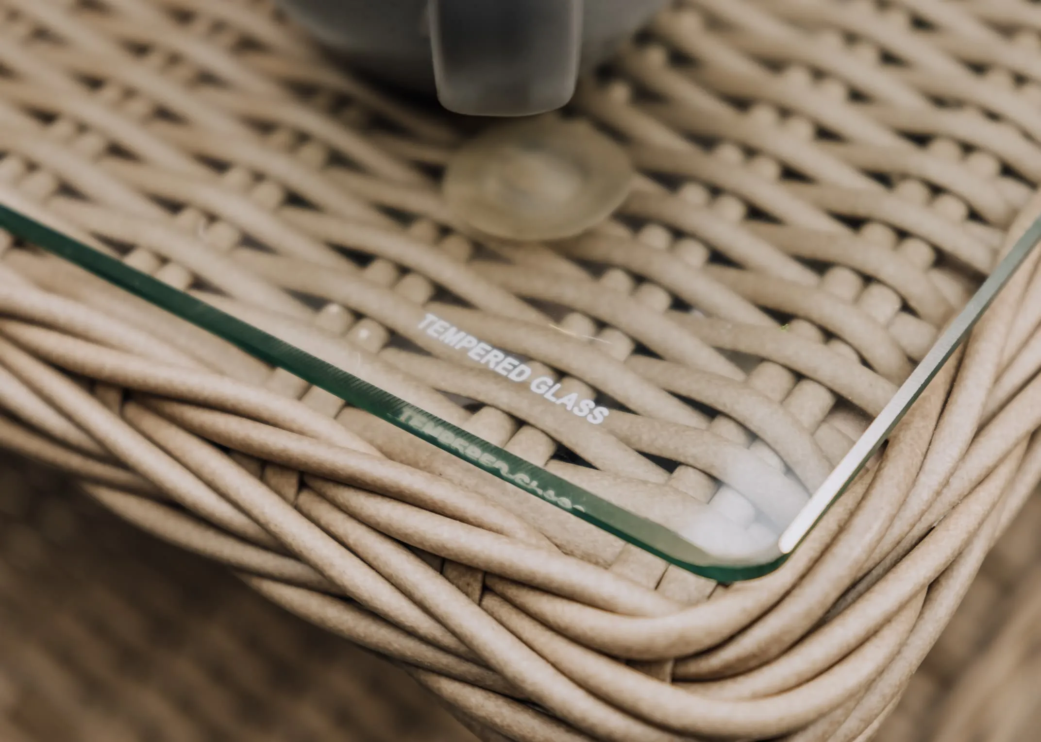 A closeup lifestyle image of the tempered glass with rattan frame.