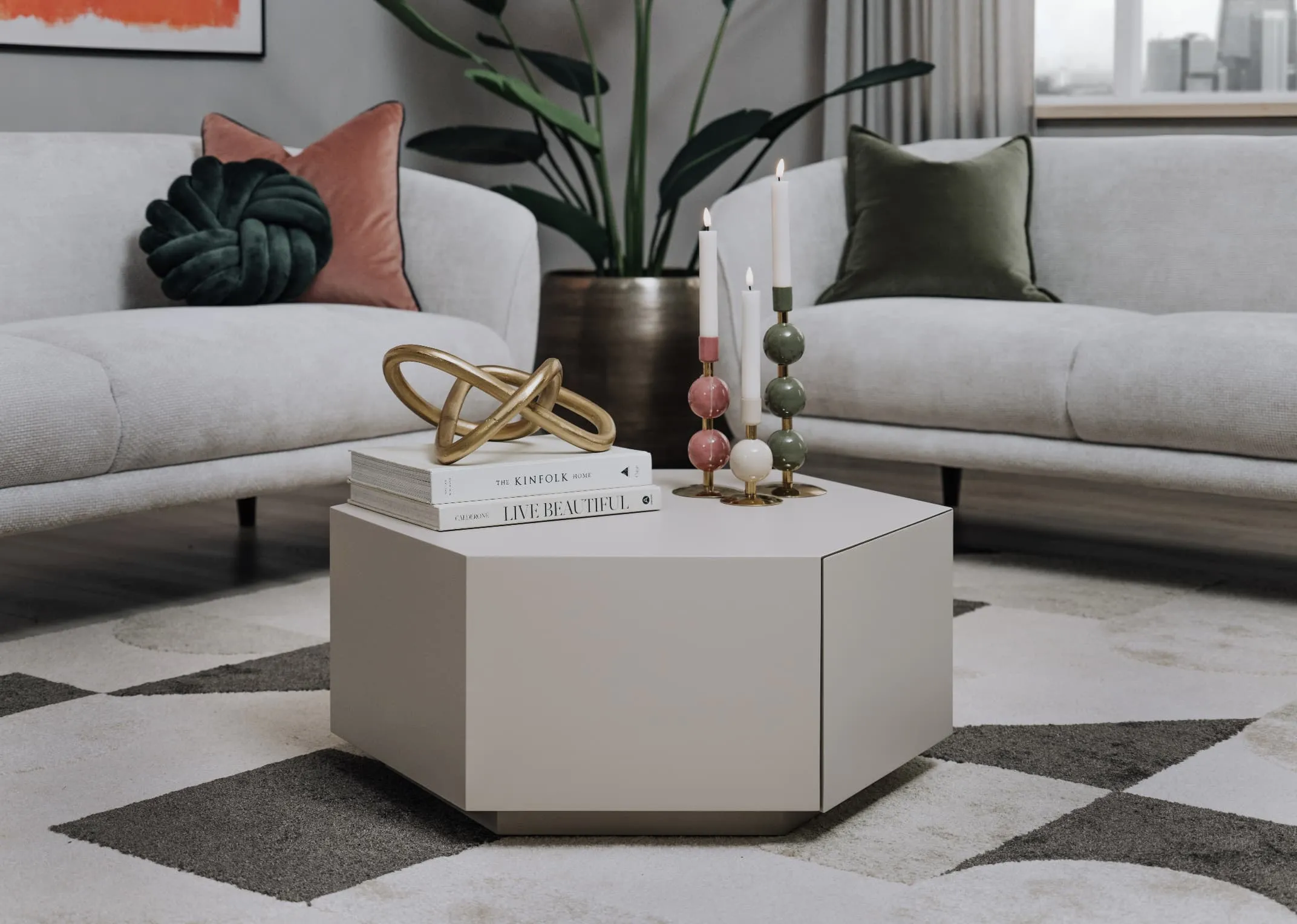 A lifestyle image of the Jonascoffee table with candle holders on top with Amber grey sofa.