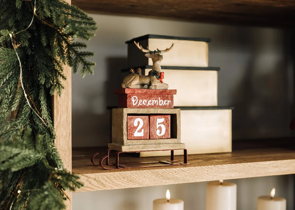 A lifestyle image of the Reindeer Calendar on a bookcase Nova displaying decmber 25th