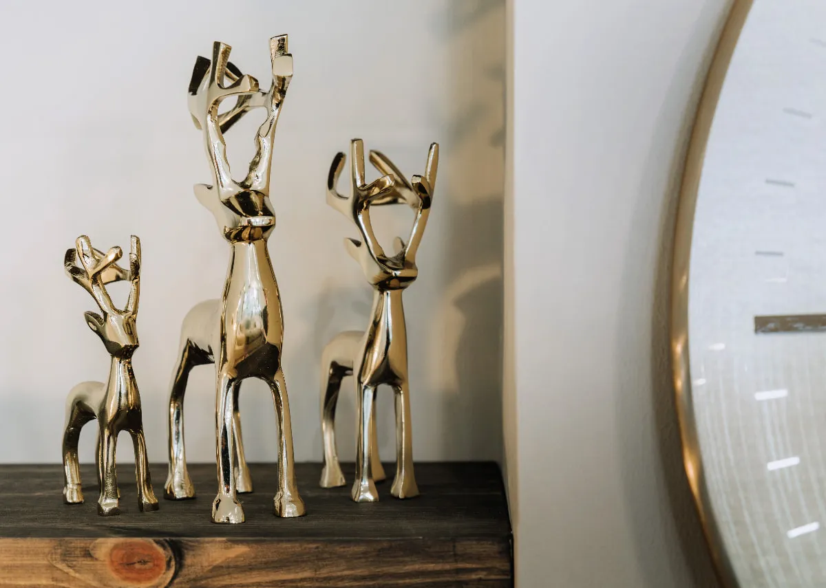 A set of 3 gold standing reindeer figurines on a shelf