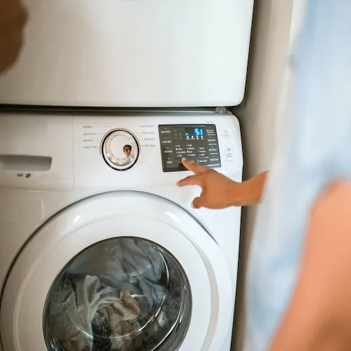 Person using washing machine.