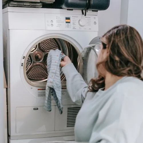 Woman putting clothes in dryer