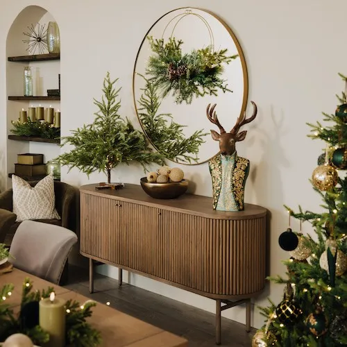 Console table decorated with Christmas ornaments and a tabletop Christmas tree at EZ Living Furniture.