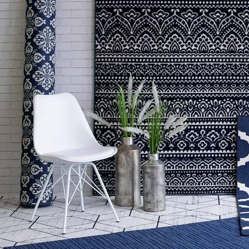 White chair with a selection of rugs from EZ Living Furniture.