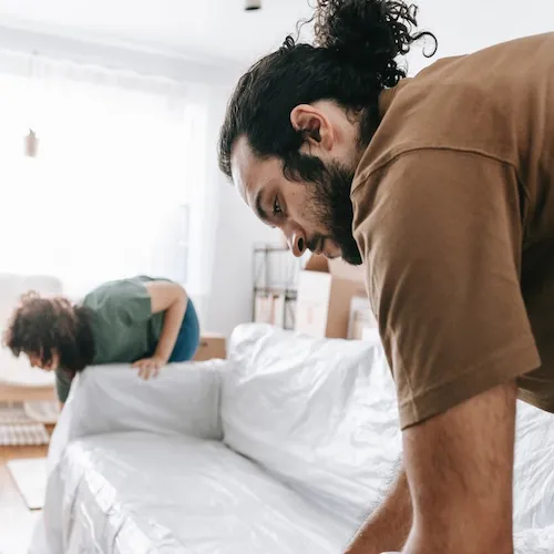 Man and woman moving sofa.