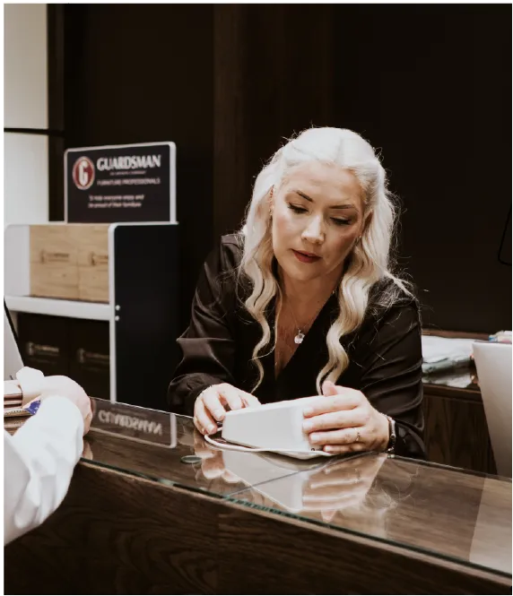 Colleague serving a customer at an EZ Living Furniture desk